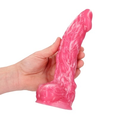 Objeto cor-de-rosa texturizado, formato alongado, segurado por uma mão