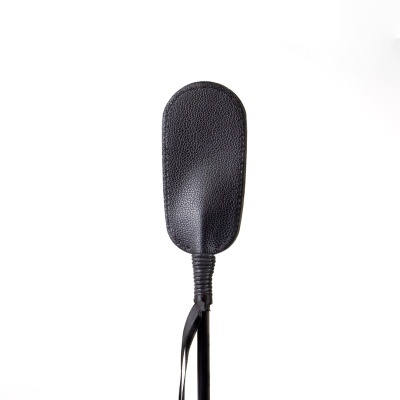 Chicote ou castigo de couro preto com pega texturizada.