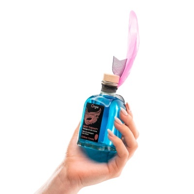 Frasco de óleo de massagem azul com decoração de pena rosa