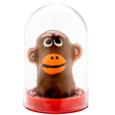 Boneco de macaco castanho com boca laranja dentro de cobertura de plástico