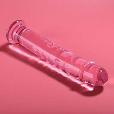Objeto de vidro transparente com textura ondulada sobre fundo rosa