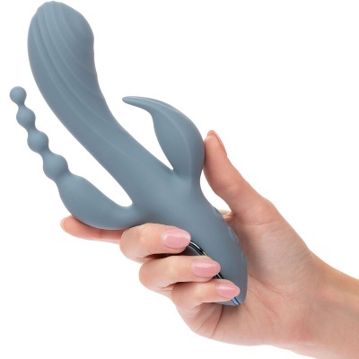Vibrador cinza em silicone segurado por mão feminina com unhas claras