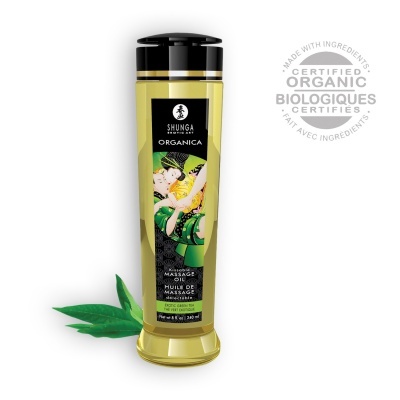 Frasco de óleo de massagem Shunga Organica com selo orgânico e folhas verdes ao lado