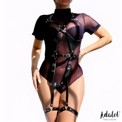 Mulher com bodysuit preto transparente e arnês de couro preto com fivelas
