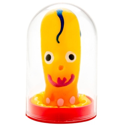 Brinquedo amarelo com olhos e boca dentro de campânula transparente com base vermelha