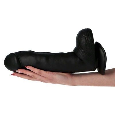 Dildo preto de silicone apoiado numa mão com unhas pintadas de vermelho