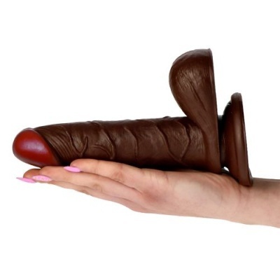 Dildo de silicone castanho escuro com ponta vermelha na mão