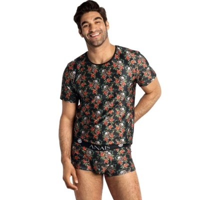 Homem com t-shirt e boxers pretos com padrão de caveiras e rosas.