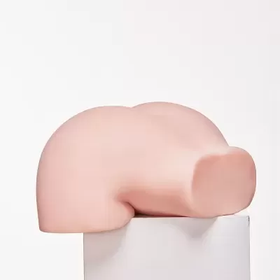 Mastro de silicone cor de pele sobre suporte branco com logótipo Sigafun