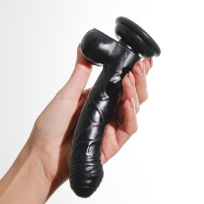 Mão segurando objeto preto curvado com texturas e base larga