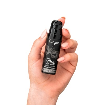 Frasco preto de gel de massagem Orgie Sexy Vibe a ser segurado por mão