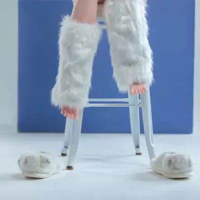 Perneiras de pelo branco e chinelos felpudos em ambiente com fundo azul e banco branco