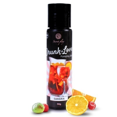 Garrafa preta de produto com etiqueta de sangria e frutas em volta