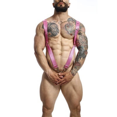 Homem musculado com tatuagens e suspensórios cor-de-rosa