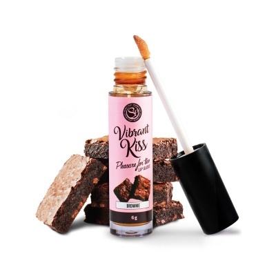 Gloss labial Vibrant Kiss com rótulo rosa e pedaços de brownie ao lado