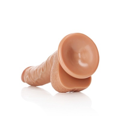 Dildo em silicone cor de pele com base larga redonda, sobre superfície branca.