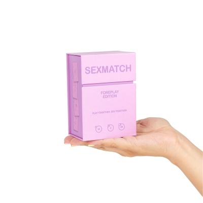 Caixa rosa do jogo SEXMATCH FOREPLAY EDITION numa mão.