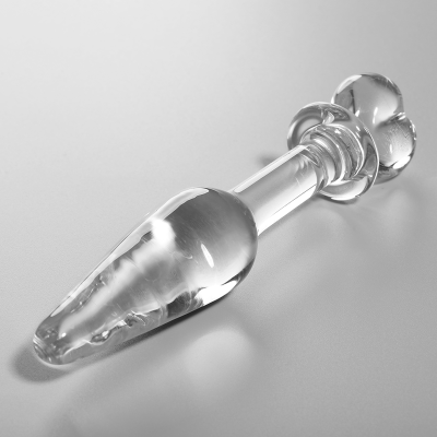 objeto de vidro transparente com base em formato de flor sobre superfície cinza