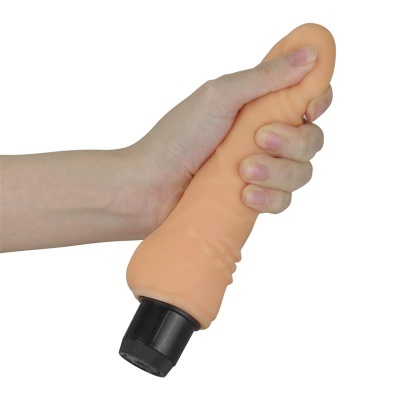 Mão a segurar vibrador cor de pele com base preta