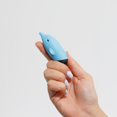 Mão a segurar um dispensador azul em forma de golfinho