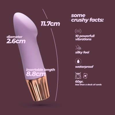 Vibrador roxo com base metálica dourada e texto descritivo das suas características, fundo bordô.
