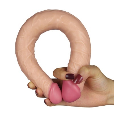 Produto em forma de U com pontas cor-de-rosa segurado por mão com unhas pintadas de roxo escuro