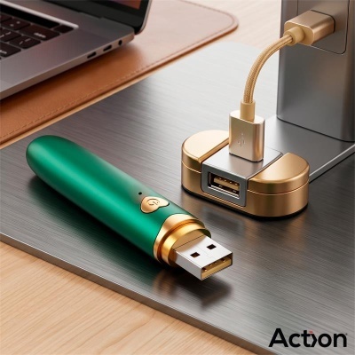 Pen USB verde com detalhes dourados junto a suporte USB dourado numa mesa metálica