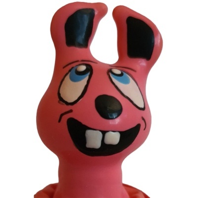 Brinquedo de borracha rosa com olhos azuis e boca sorridente