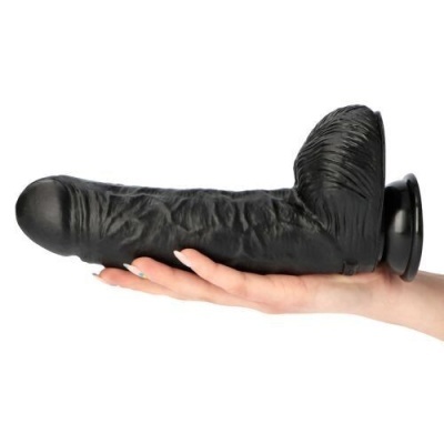 Dildo preto detalhado com ventosa sendo segurado por uma mão