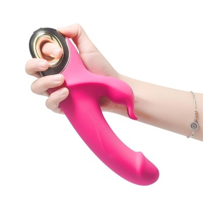 Vibrador cor-de-rosa com detalhe preto e dourado segurado por uma mão