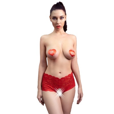 Mulher com cueca vermelha de renda e adesivos de coração KISS ME! nos seios