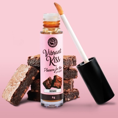Frasco de gloss labial com rótulo rosa e pedaços de brownie em fundo rosa