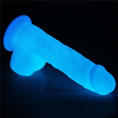 Produto em forma de pênis azul fosforescente sobre superfície escura