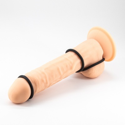 Dildo cor de pele com três anéis pretos e cauda curva