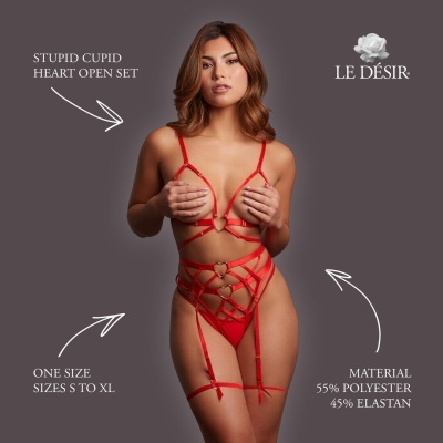Conjunto de lingerie vermelho com fitas e corações metálicos em fundo cinzento.