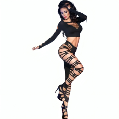 Mulher com conjunto preto de top e leggings com recortes e saltos altos pretos