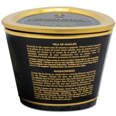 Vela de masajes en recipiente negro con tapa dorada y texto en español y alemán