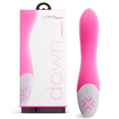 Vibrador cor magenta com base branca e botões, ao lado da embalagem
