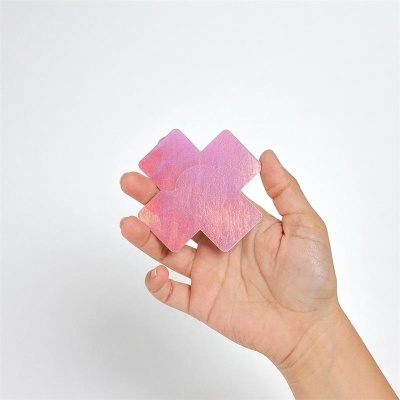Aplique em forma de cruz iridescente rosa e lilás na mão
