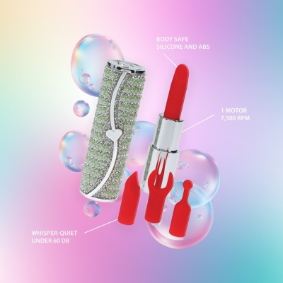 Vibrador tipo batom com decoração brilhante e acessórios vermelhos em fundo colorido