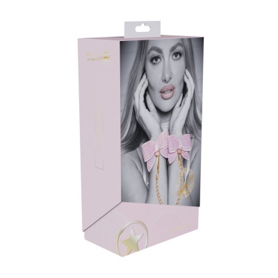 Caixa cor-de-rosa clara com imagem de mulher a usar algemas cor-de-rosa com laços e corrente dourada