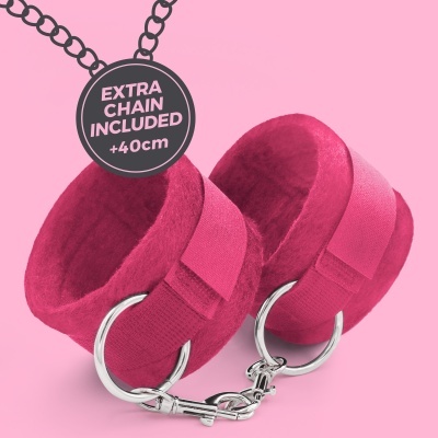 Algemas de veludo rosa com partes metálicas prateadas e etiqueta informativa sobre fundo rosa