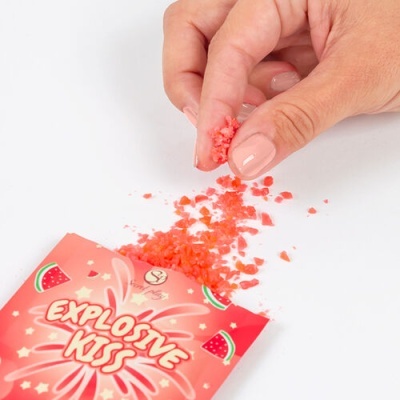 Pacote vermelho Explosive Kiss com cristais vermelhos sendo pegues por uma mão