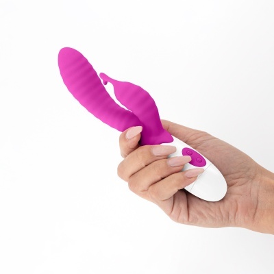 Vibrador rosa segurado por uma mão