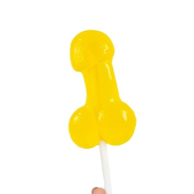 Pirulito amarelo em forma fálica segurado por uma mão
