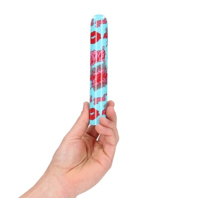 Objeto cilíndrico azul com desenhos vermelhos e rosas e palavras OMG, Oh yeah, Bang segurado por uma mão.