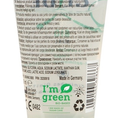 Tubo plástico transparente com tampa verde e texto informativo multilíngue.