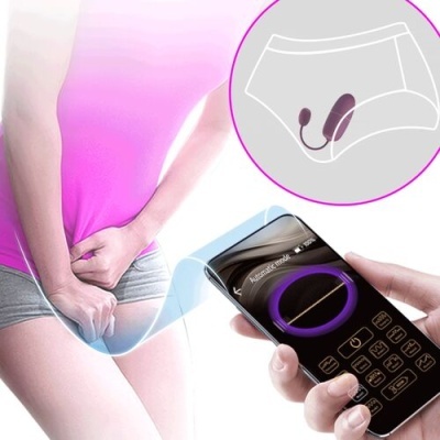 Pessoa com roupa interior cinza e camiseta rosa segurando área púbica com uma mão e controlo remoto com smartphone com interface digital, ilustração de cueca branca com aparelho anexado