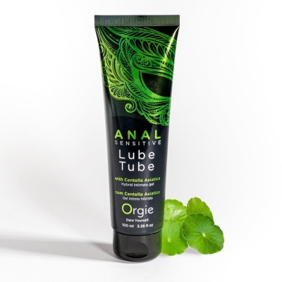 Tubo de gel íntimo híbrido preto com padrão verde e texto, com folhas verdes ao lado