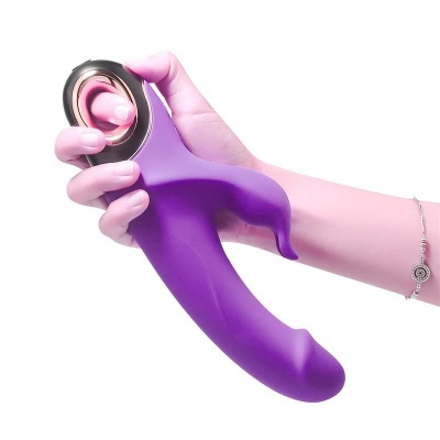 Vibrador roxo em silicone com punho preto e detalhe dourado segurado por uma mão
